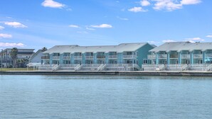Ein Strandhotel mit mehrstöckigen Gebäuden, Balkonen und Blick auf das Wasser.