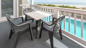 Ein Balkon mit Pool, einem Tisch und vier Stühlen.