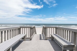 A wooden boardwalk leading to the beach with a clear view of the ocean.