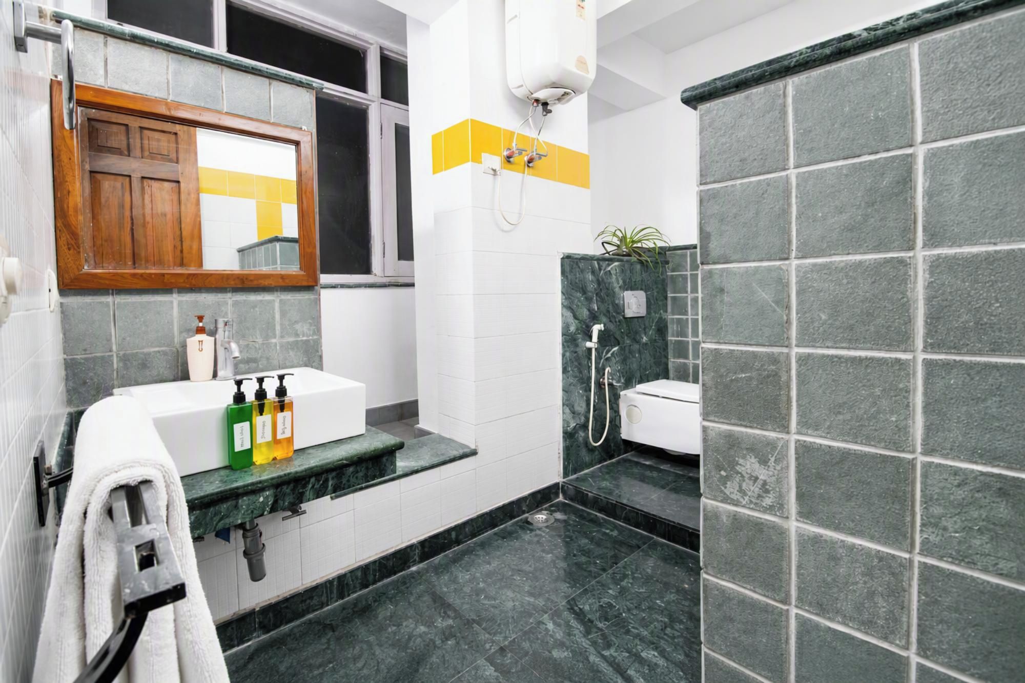 A bathroom with a white sink, a mirror, a towel rack, and a shower area.