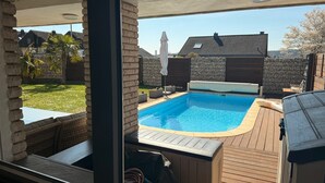 A backyard with a swimming pool, a hot tub, and a wooden deck. - Wellness in the Eifel for Ages 16 and Up (Mechernich)