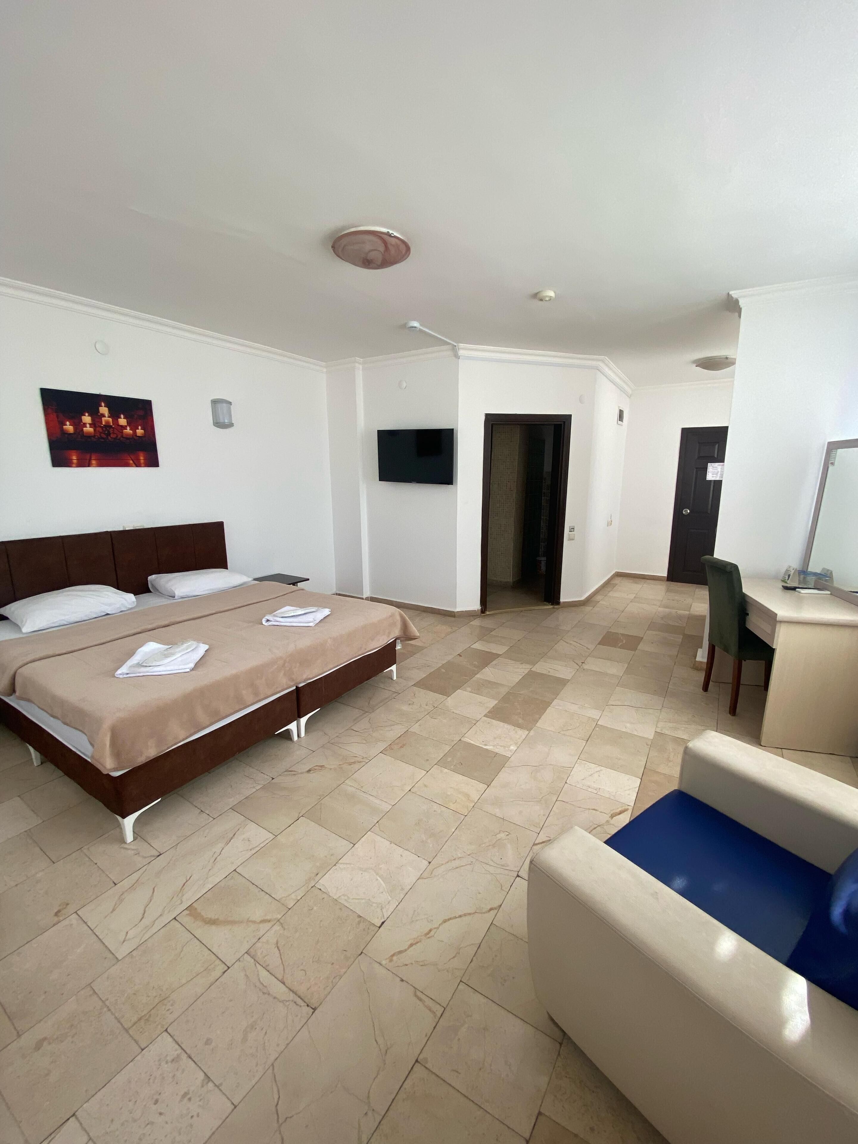 A hotel room with a bed, a desk, and a chair.