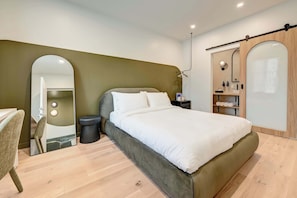 A modern bedroom with a bed, a chair, a mirror, a wardrobe, and a small shelf with toiletries. - Rare 4-Bed, 4 Private Ensuites, Full Kitchen in Trendy Montreal Neighbourhood (Montréal)