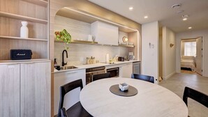 Una cocina moderna con una mesa de comedor redonda, estantes empotrados y un diseño compacto.