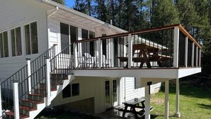 A two-story house with a covered deck and a staircase leading to the upper floor. - Private, luxury, 4-bedroom home minutes from downtown Bigfork (Bigfork)