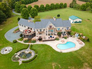 A large house with a swimming pool, a covered patio, and a landscaped garden. - Minutes from Downtown Easton and St. Michaels | Pool | Kayaks | Private Dock (Easton)
