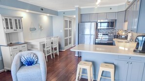 A modern kitchen with a large island, stainless steel appliances, and light blue cabinetry.