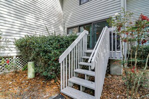 A wooden staircase leading to a house with a window and a hedge. - Pet-Friendly 3BR/3BA Villa, Sleeps 8 | 3 Pools, 4 Bikes, 10-Min Walk to Beach (Hilton Head Island)