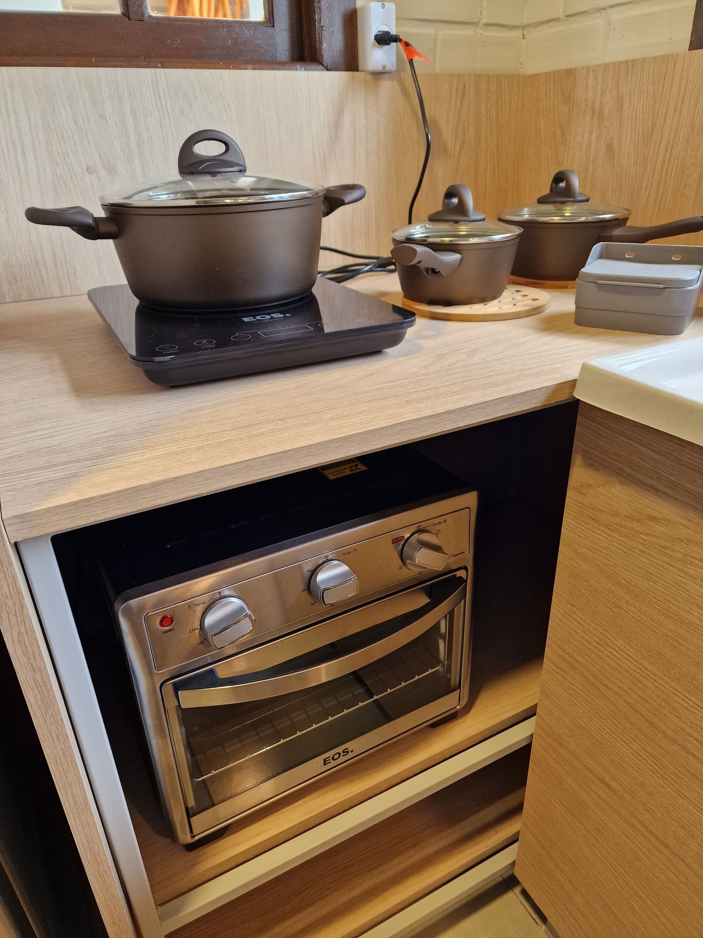 A kitchen with an induction cooktop, an oven, and a pot on the cooktop.