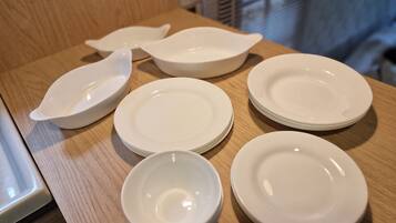 Un ensemble d’assiettes et de bols blancs, posés sur une table en bois.