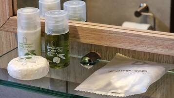 A bathroom shelf with various toiletries including body lotion, shower gel, and a bar of soap.