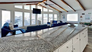 A modern kitchen with a granite countertop, white cabinets, and a built-in oven. - Bellcove | Waterfront + Boat Dock/Slip (Surf City)