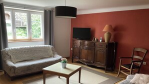 Una sala de estar con un sofá, una mesa de centro y un mueble para la televisión.