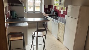 Una cocina compacta con refrigerador, pileta y ventana.