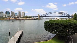 Une vue sur le front de mer, avec un pont, des bateaux et le profil de la ville en arrière-plan.