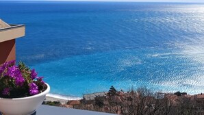 A balcony with a view of the sea and a building with a potted plant. - The Sundevilla Designer Penthouse with sea view terrace, parking space and pool (Bergeggi)