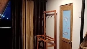 Una habitación con techo de madera, una puerta de madera con un panel de vidrio y una escalera de madera, además de una alfombra roja.