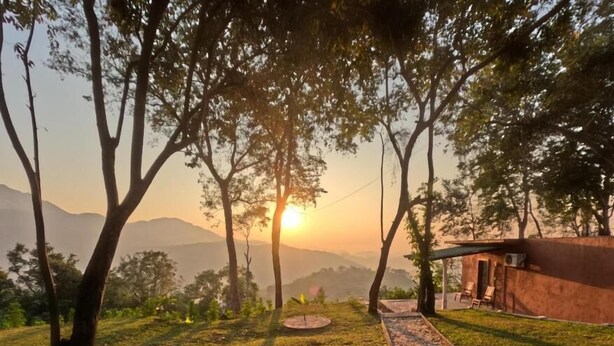 Un camino que lleva a un edificio con vistas a montañas al fondo.