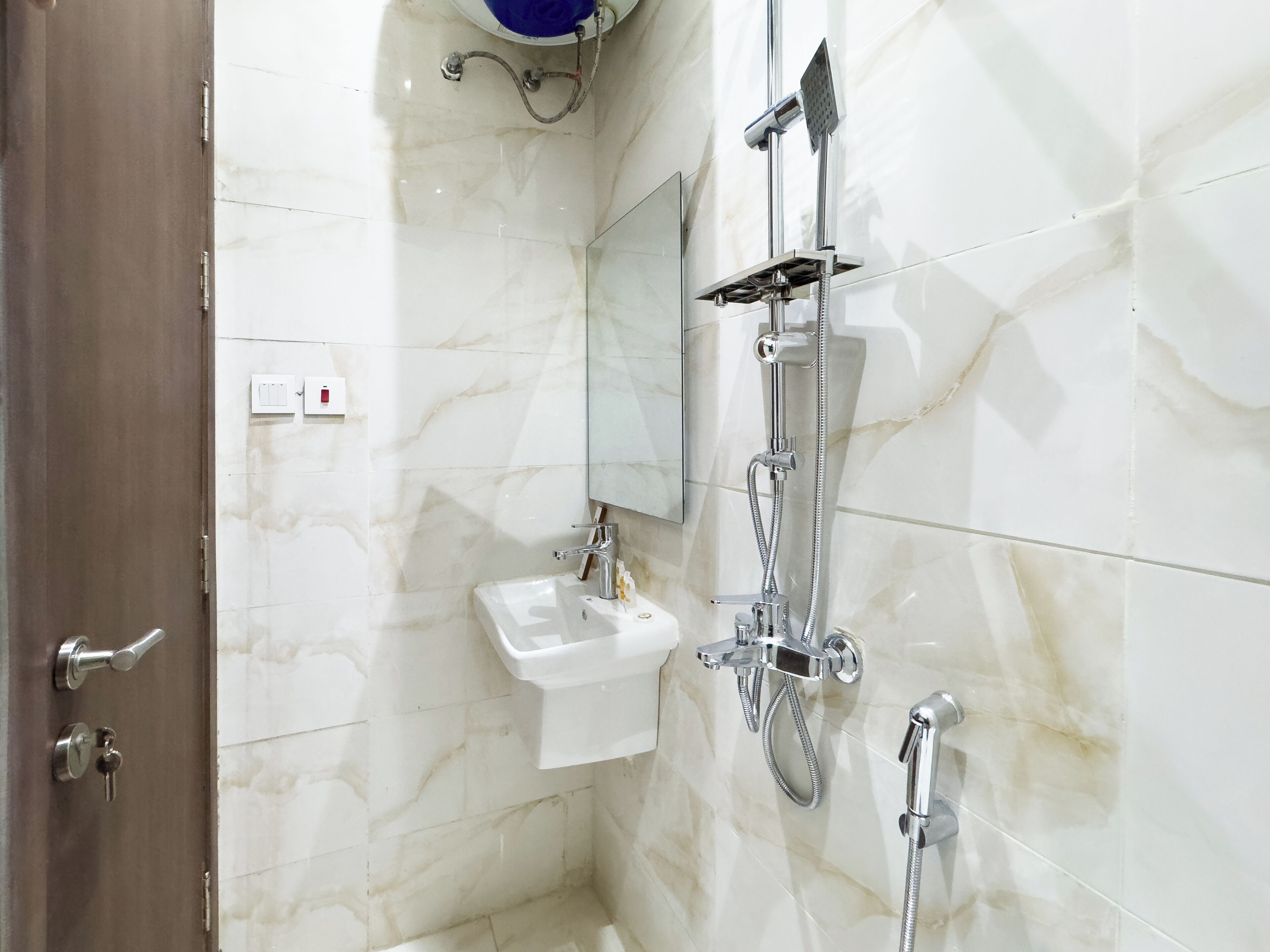 A bathroom with a sink, a mirror, and a shower.