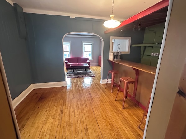 A spacious living room with hardwood flooring, a red sofa, and a coffee table. - Fun 2-bedroom downtown 2ND FLOOR loft style apartment with WiFi and theater room (Virginia)