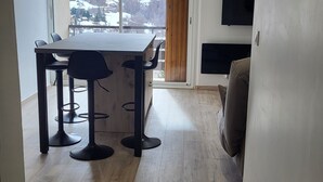 A modern kitchen with a large island, wooden flooring, and a view of snowy mountains through the window. - SEASONAL RENTAL RENOVATED STUDIO 35M2 IN ORCIÈRES (ORCIÈRES)