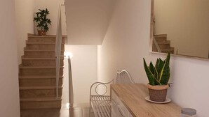Une cuisine moderne avec un plan de travail en bois, une plante en pot, un miroir et un escalier menant à un autre niveau.