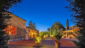 A courtyard with a building featuring large windows and a pergola.
