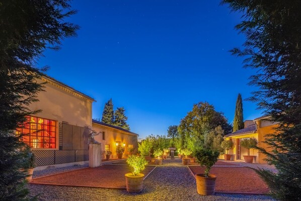 A courtyard with a building featuring large windows and a pergola.