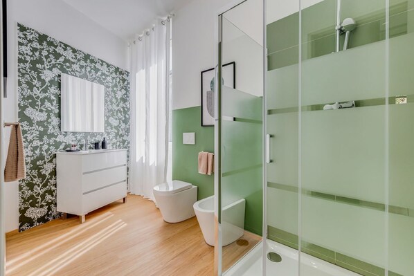 A modern bathroom with a shower, toilet, and vanity.