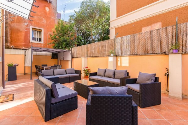 A patio with outdoor furniture, including sofas and chairs, and a pergola providing shade. - Esher Residence - Four Bedroom Villa, Sleeps 8 (Rome)
