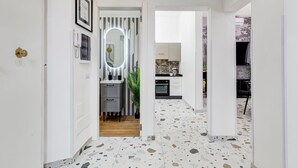 Una cocina moderna con armarios blancos, encimera negra y horno empotrado.