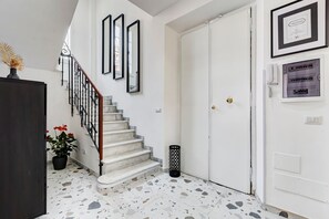 A staircase with a marble finish, a white door with a gold handle, and a framed certificate on the wall. - Esher Residence - Four Bedroom Villa, Sleeps 8 (Rome)