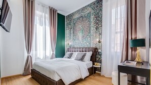 Un dormitorio con cama, mesita de noche, lámpara y un muro con un mural detallado.