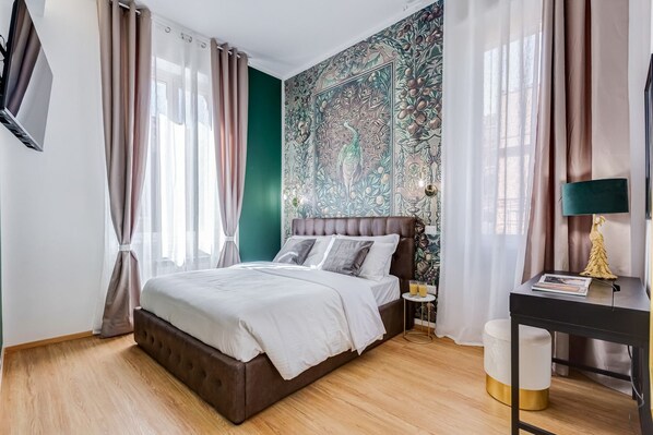 Ein Schlafzimmer mit einem Bett, einem Nachttisch, einer Lampe und einer Wand mit Wandgemälde.