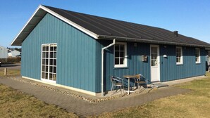 Un petit bâtiment d’un seul étage, à l’extérieur bleu foncé et doté d’un toit métallique incliné.