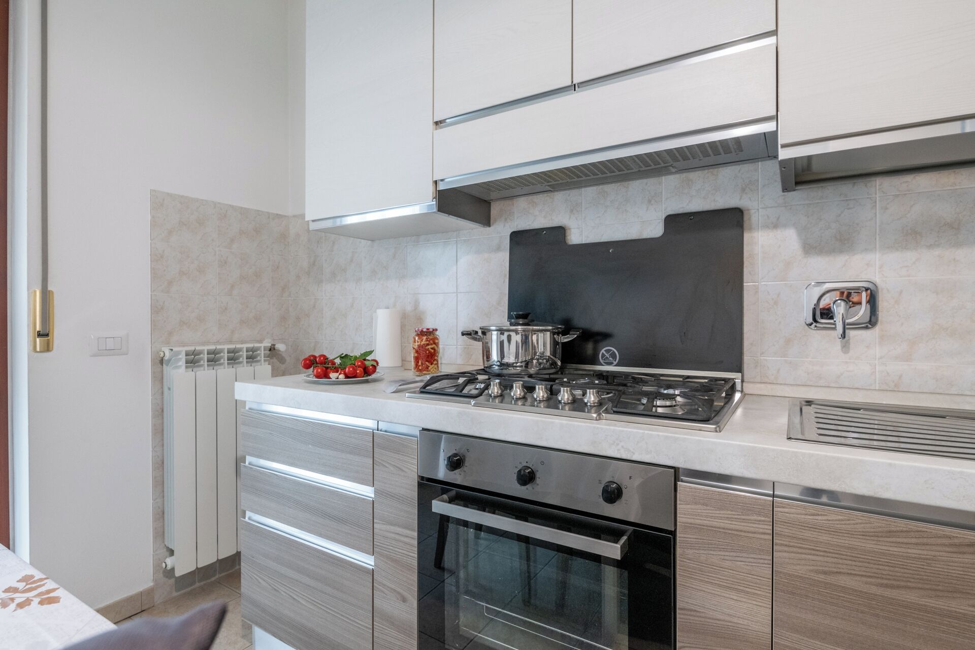 A modern kitchen with a stainless steel stove, oven, and a black backsplash.