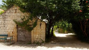 A stone building with a bench outside, surrounded by trees. - Marinero-sea Breeze Escape in Zuljana (Ston)