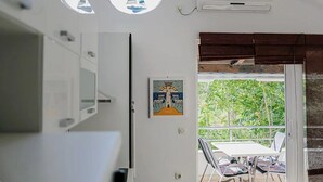 A room with a white cabinet, a painting, and a window with a sailboat. - Marinero-sea Breeze Escape in Zuljana (Ston)