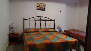 Un dormitorio con una cama, una mesita de noche y un cuadro en la pared.