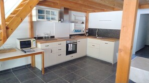 A compact kitchen with a microwave, oven, and sink.