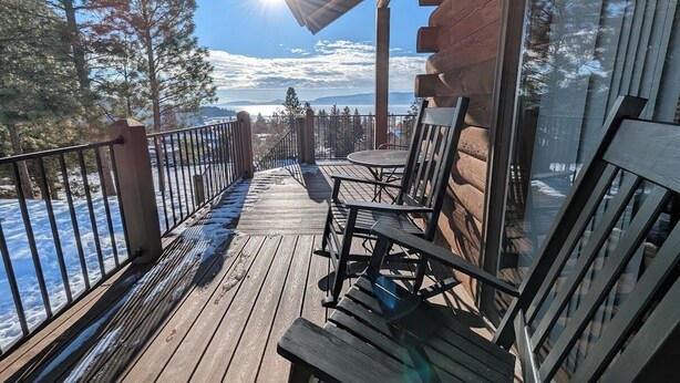 A wooden deck with a view of a snowy landscape and mountains. - Cedar & Sky Retreat- Rustic Lakeview Cabin (Bigfork)