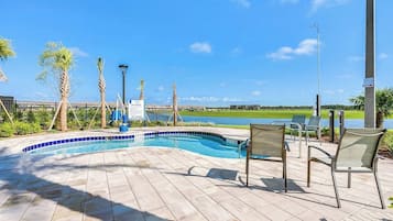 Relax by the pool surrounded by palm trees and enjoy a clear view of the nearby water.