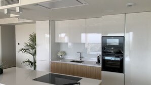 Une cuisine moderne dotée d’un îlot central, d’appareils électroménagers intégrés et offrant une vue sur la ville.