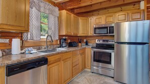 Una cocina moderna con armarios de madera, electrodomésticos de acero inoxidable y encimeras de granito.