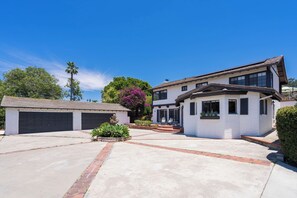 A two-story house with a driveway, garage, and a well-maintained garden.
