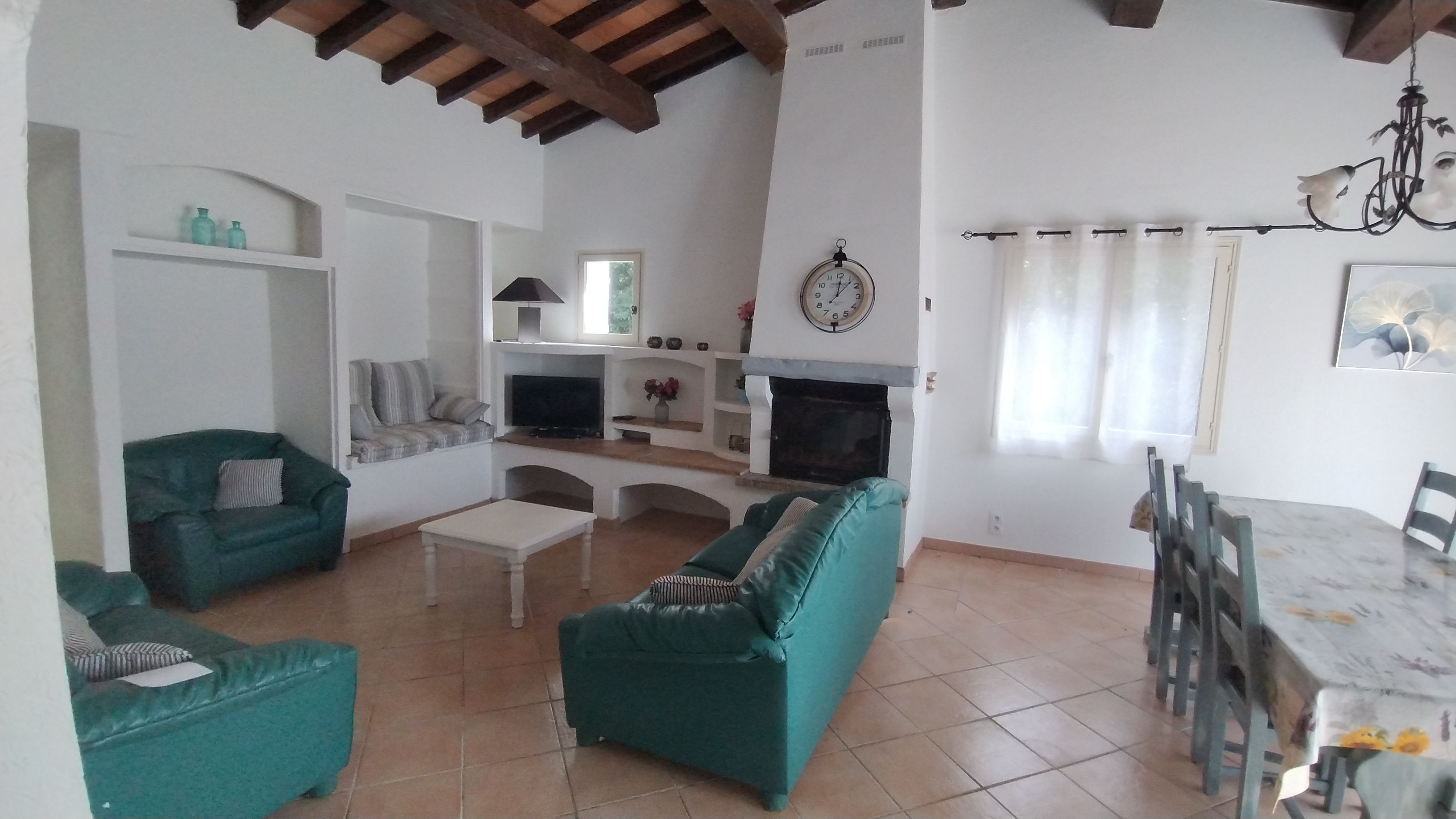 A living room with a sofa, a coffee table, a TV, and a fireplace.