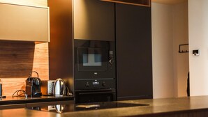 Una cucina moderna dotata di forno a microonde, forno e macchina per il caffè.