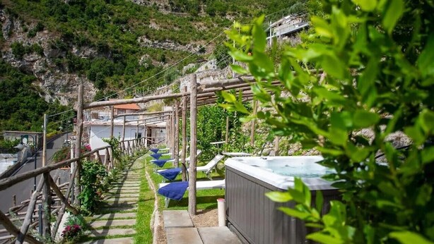 A pathway leading to a hot tub with a view of a mountainous landscape. - Van Gogh Room (Amalfi)