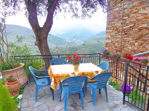 A terrace with a table and chairs, overlooking a valley. - Casa Mamma Rosetta, one Step Away From the Sea, the Mountains and the Cycle Path (Civezza)