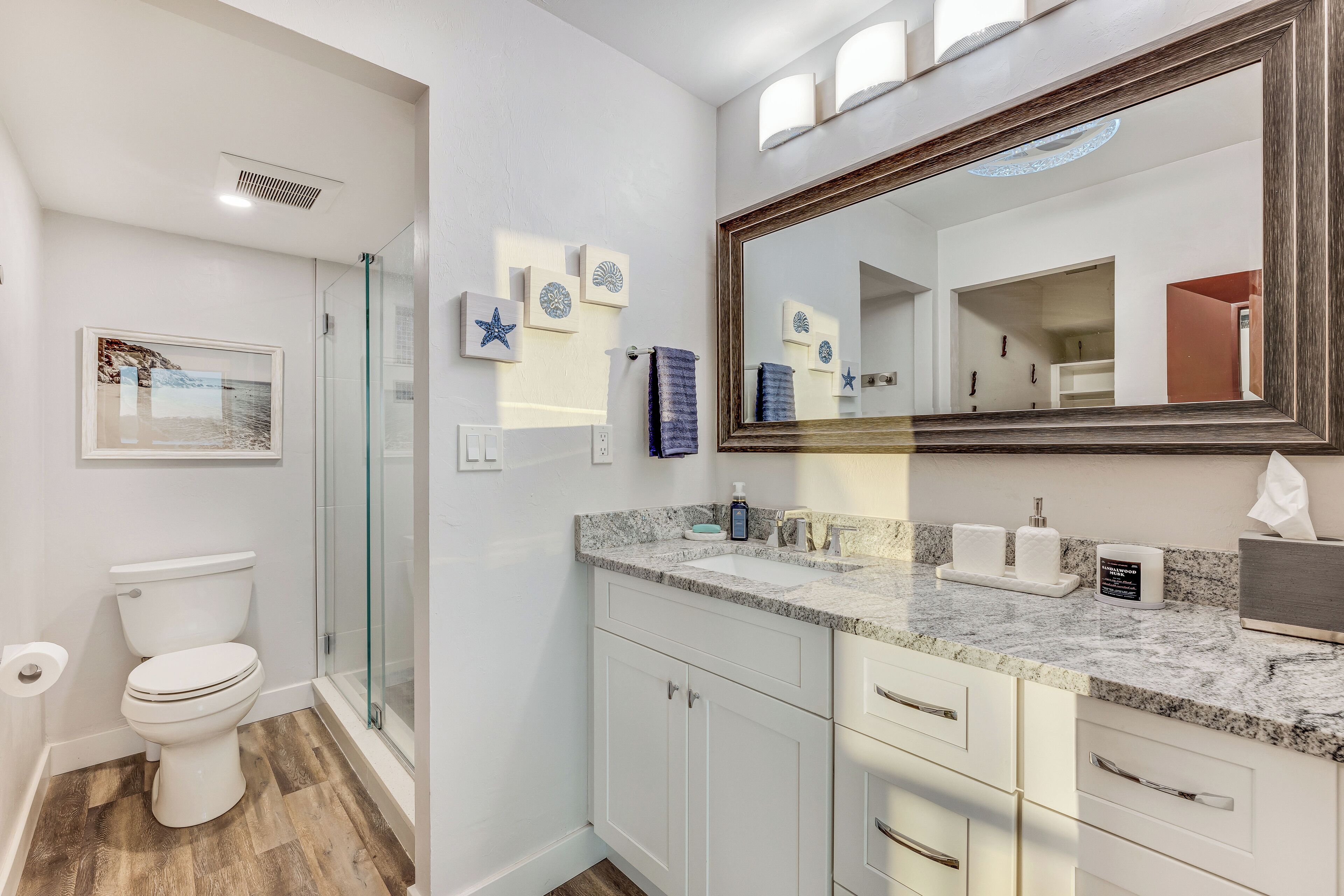 A bathroom with a toilet, shower, and sink.